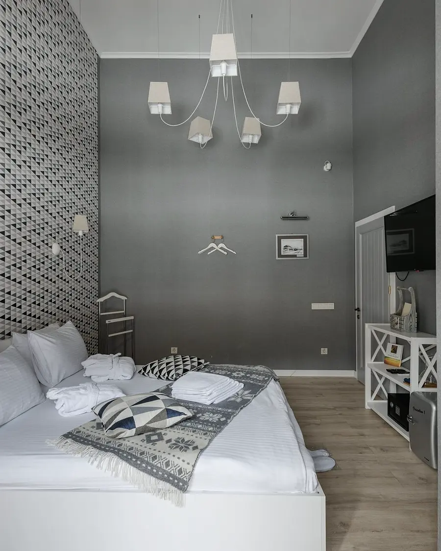 Quarto de hospedagem com cama arrumada e luz natural entrando pela janela